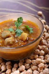 indian spicy chana masala, raw chickpeas around bowl