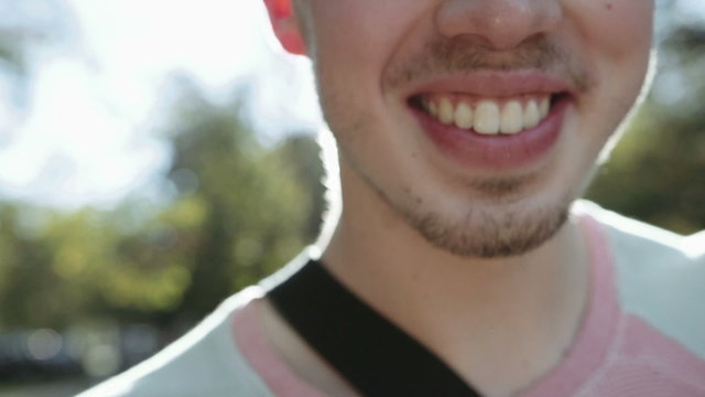 Close up of cheerful young man face smiling widely.