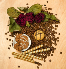 dry red roses and cookies on coffee seeds