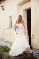 Fototapeta premium Blonde bride by old house