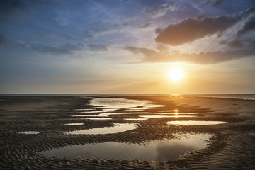 Fototapeta na wymiar Beautiful vibrant Summer sunset over golden beach landscape