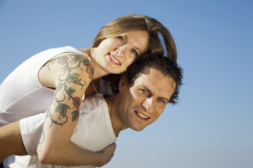 Chica rubia con tatuaje abrazando a su chico