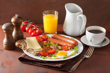 english breakfast with fried egg sausages bacon tomatoes beans