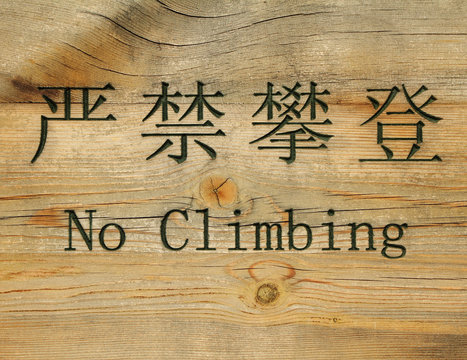 prohibition sign in chinese and english : no climbing