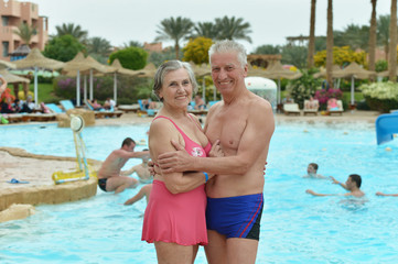 Obraz na płótnie Canvas Senior couple standing by pool