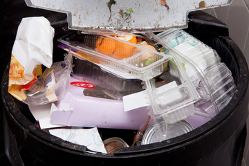 Garbage can full of mixed unsorted trash. Nature pollution and sustainability concept. 