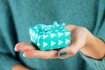 Close-up of female hand holding a present, gift.