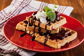 Waffles with chocolate sauce, whipped cream and confiture