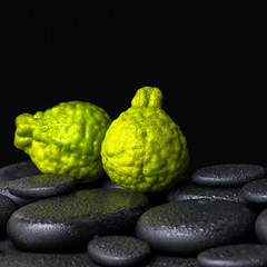 Fototapeta premium Aromatic spa concept of bergamot fruits on zen basalt black ston