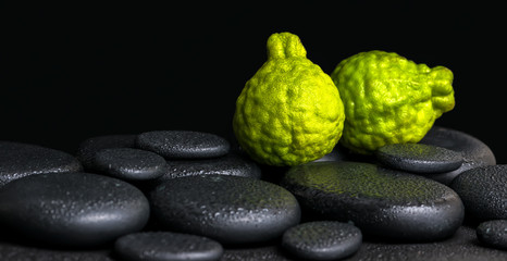 Aromatic spa concept of bergamot fruits on zen basalt black ston