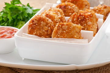 Chicken nuggets coated in cereals, crumbs and sesame
