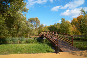 Fototapeta na wymiar Wooden bridge across small river