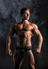 Fototapeta na wymiar Attractive shirtless muscular man standing in underwear