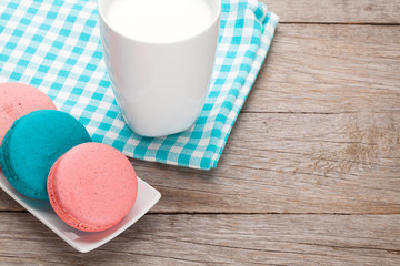 Colorful macaron cookies and cup of milk