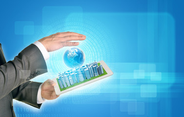 Man hands using tablet pc. Business city on touch screen. Earth