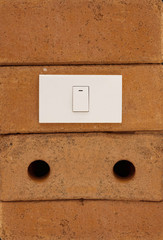 Light switch on red brick wall
