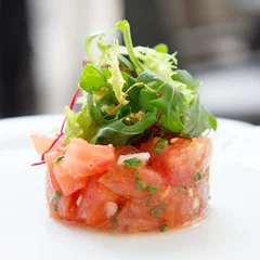 Fotobehang Tomato tartare topped with green salad. © Moving Moment