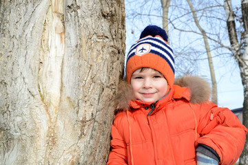 boy in winter near the tree in the park