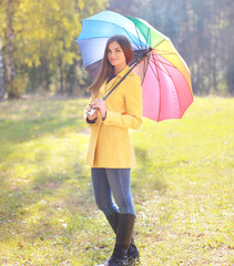 Beautiful woman with colorful umbrella outdoors in autumn day