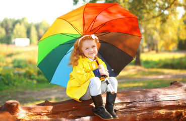 Autumn portrait little girl with colorful umbrella outdoors in p