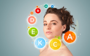 Pretty young girl with colorful vitamin icons and symbols