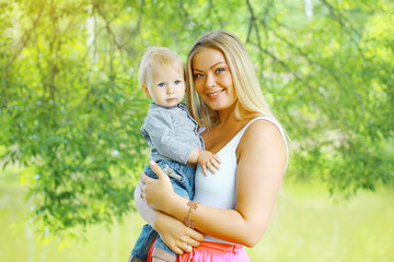 Fototapeta premium Happy mother and baby in sunny summer day