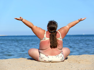 overweight woman on beach with hands up