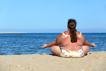Fototapeta na wymiar overweightl woman meditation on beach