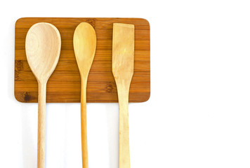 wooden spatula and two spoons on a  cutting board