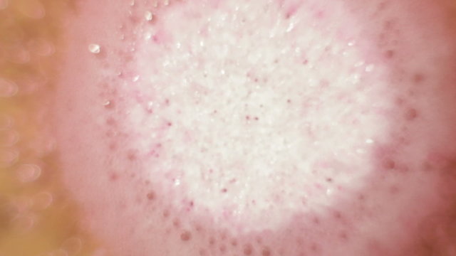 Pink effervescent tablet bubbling in water