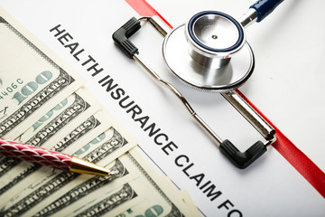 Health insurance application form with banknote and stethoscope