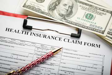 Health insurance application form with banknote and stethoscope