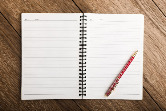 blank notebook with pen on wooden table