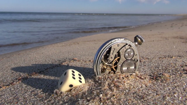 sea and lucky time concept- clock and dice on beach