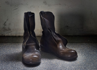 Dirty old brown boots over blue grunge background