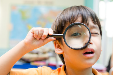 Little boy looking trough a binoculars map background