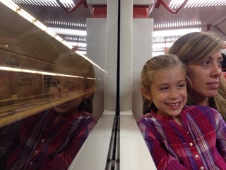 Mother and daughter reflected in a train window