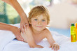 Adorable little blond kid relaxing in spa with having massage