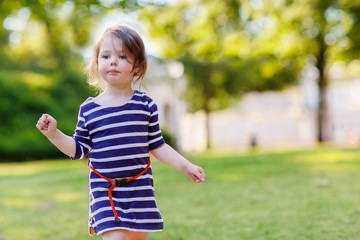 Portrait of adorable little kid girl in summer park