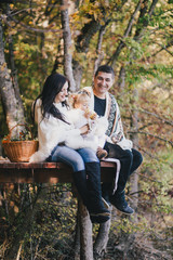 Naklejka na ściany i meble Happy family in an autumn forest near lake