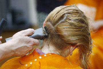 Fototapeta premium Blonde Haircut at the Salon with Hair Trimmer