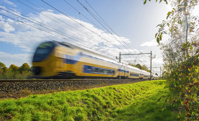 Obraz premium Passenger train moving at high speed in sunlight
