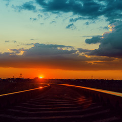 Fototapeta premium low sun over railroad to horizon in sunset