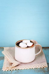 Cup of tasty hot cocoa, on wooden table, on color background