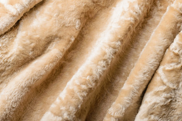 Folds and waves in a warm blond sheepskin Jacket