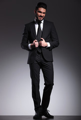 business man looking at the camera while fixing his jacket