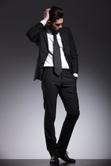 young business man fixing his hair while looking down