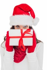 Brunette in red gloves and santa hat showing gift