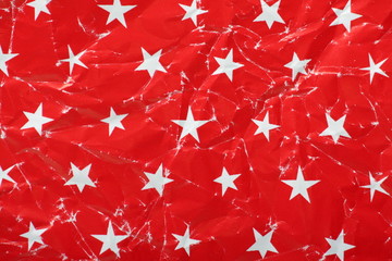 Fototapeta premium Used Christmas wrapping paper with white stars on red