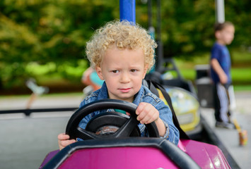 a little boy driving a bumper car